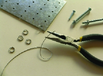 STEP 2: Simply connect three or four plates using a short length of wire. Using needlenose pliers, thread the wire through adjacent holes on two different plates. Send the ends of the wire back through the opposite hole and double the circle of wire around on itself until you’ve made a ring with overlapping ends like a key ring. Alternatively, twist the wire around itself like a twist-tie.